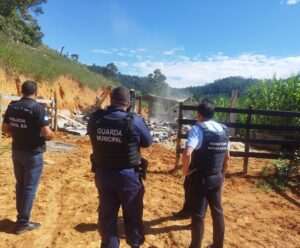 Guardas municipais e agentes observando a demolição do abatedouro clandestino