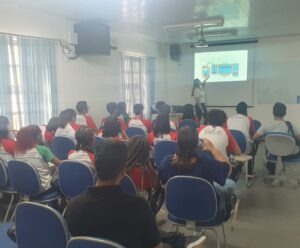 BRK recebe mais 146 estudantes de escolas públicas de Cachoeiro Os alunos estão todos sentados de frente a uma tela de slide, escutando uma palestra.