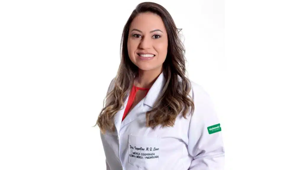 mulher de cabelos compridos sorrindo usando jaleco