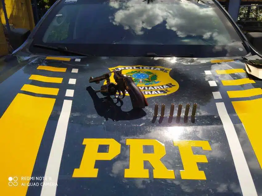 arma e balas em cima do capo de carro da PRF