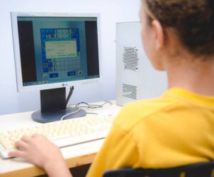 Anchieta abre vagas para curso de informática básica Uma mulher esta de costas, usando o computador.
