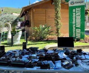 Foto mostra mesa lotada de resíduos eletrônicos em frente a sede da Secretaria de Meio Ambiente de Guaçuí