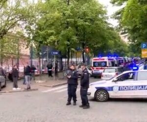 carro de polícia e policiais em frente a escola na Sérvia