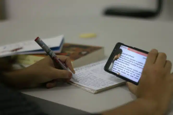 pessoa estuda com celular na mão