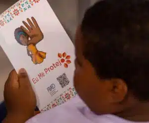 Imagens de abuso sexual infantil online crescem 70% no Brasil em 2023 criança segurando uma cartilha contra o abuso sexual infantil