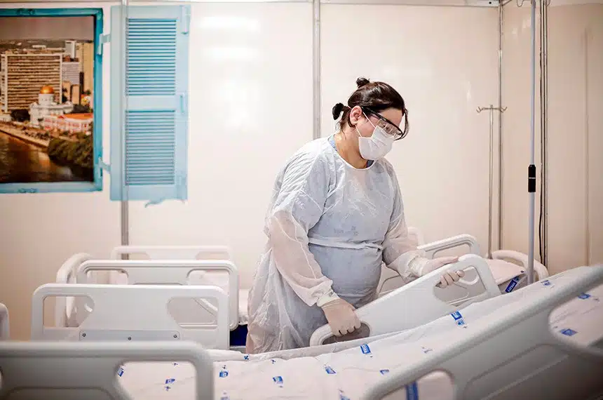 enfermeira ao lado de um leito de hospital