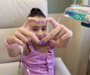 Menina de 10 anos, que mora em UTI, faz campanha por doação de órgãos menina em quarto de hospital fazendo um coração com as mãos