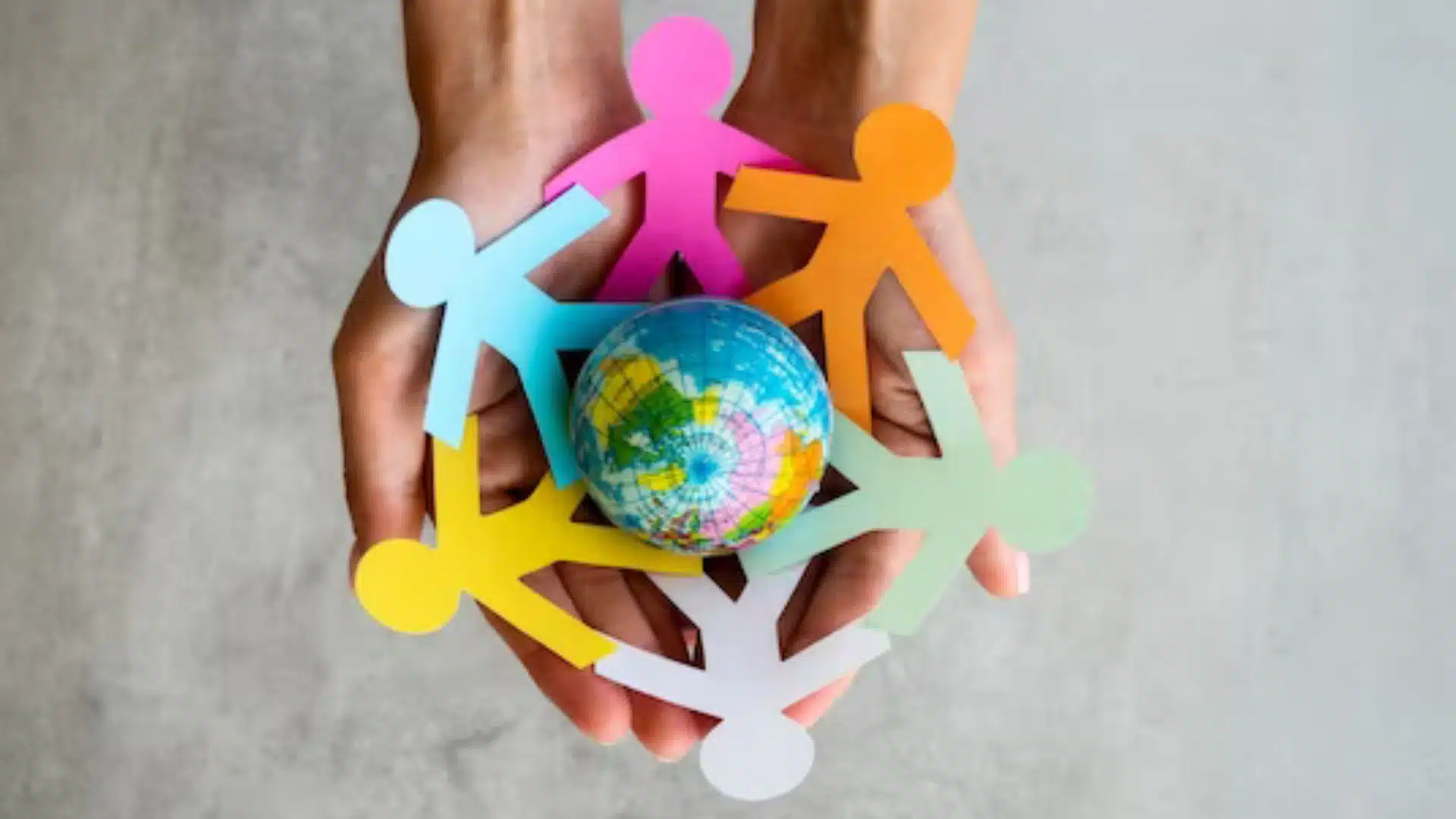 mãos seguram bonecos de papel e o mundo