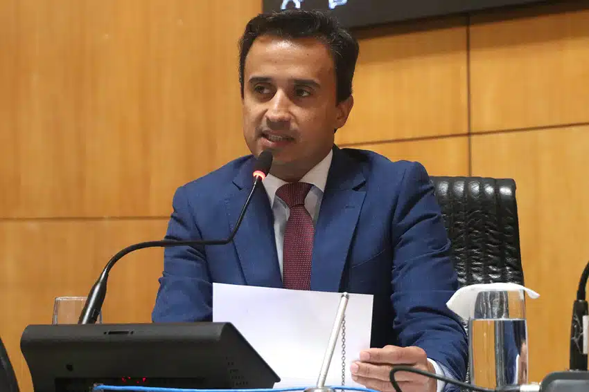 Deputado em uma bancada com projeto de lei na mão