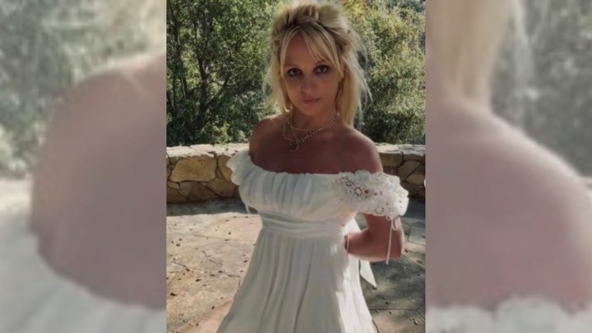 A cantora aparece com um vestido branco e babados nas mangas, pérolas no pescoço e com o cabelo meio preso.