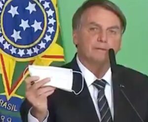 ex presidente Jair Bolsonaro segurando máscara
