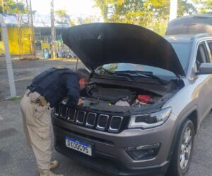 Morador de Cachoeiro é flagrado com Jeep roubado em rodovia do ES Policial vistoriando motor de um Jeep Compass