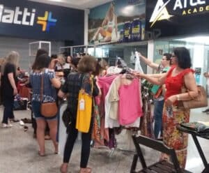 Bazar da Santa Casa terá roupas de grife a partir de R$10 Pessoas olhando roupas