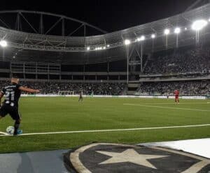 Atleta do Botafogo cobrando um escanteio com a bola dentro do estádio