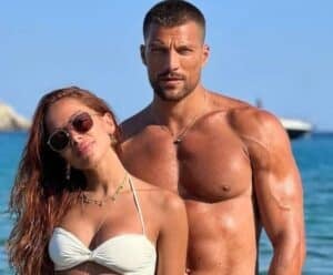 Anitta se irrita com comentário sobre namoro com astro de ‘365 Dias’ Anitta com o namorado, simone com praia ao fundo da foto.