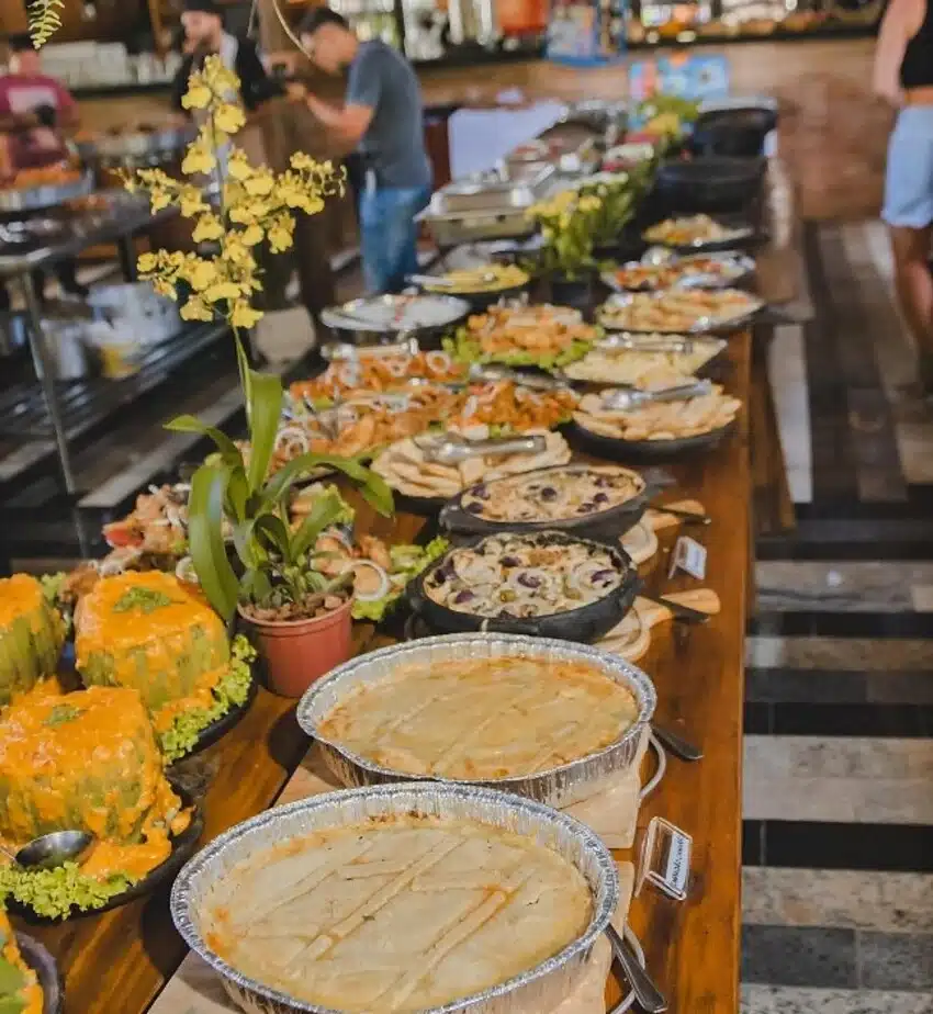 Foto com mesa cheia de pratos servidos em atrativo do turismo em Iúna