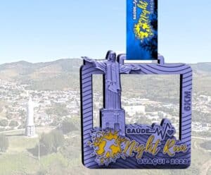 Neste sábado (9) tem Corrida e Caminhada Saúde Night Run Foto mostra a medalha que vai ser entregue a quem participar do Saúde Nigth Run, em Guaçuí, neste sábado (9), tendo o fundo vista da cidade