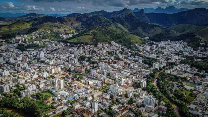 Cidade de Castelo no Espírito Santo, imagem mostra a cidade vista do alto, mosrando as montanhas ao fundo e o céu azul