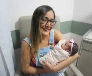 A jornada de uma mãe de bebê prematuro e o preparo para o nascimento Mãe segurando o bebê prematuro