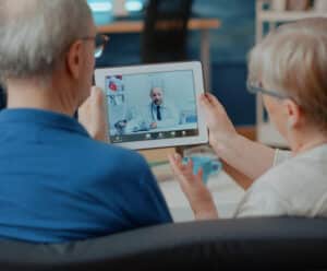 Unimed Sul Capixaba inicia o novo serviço do Pronto Atendimento Digital Casal senior fazendo consulta em tablet