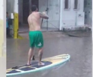 Vídeo | Homem usa prancha de surf durante alagamento em Marataízes