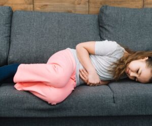 Gastroenterite: o que é, sintomas e cuidados A foto apresenta uma criança com dor abdominal