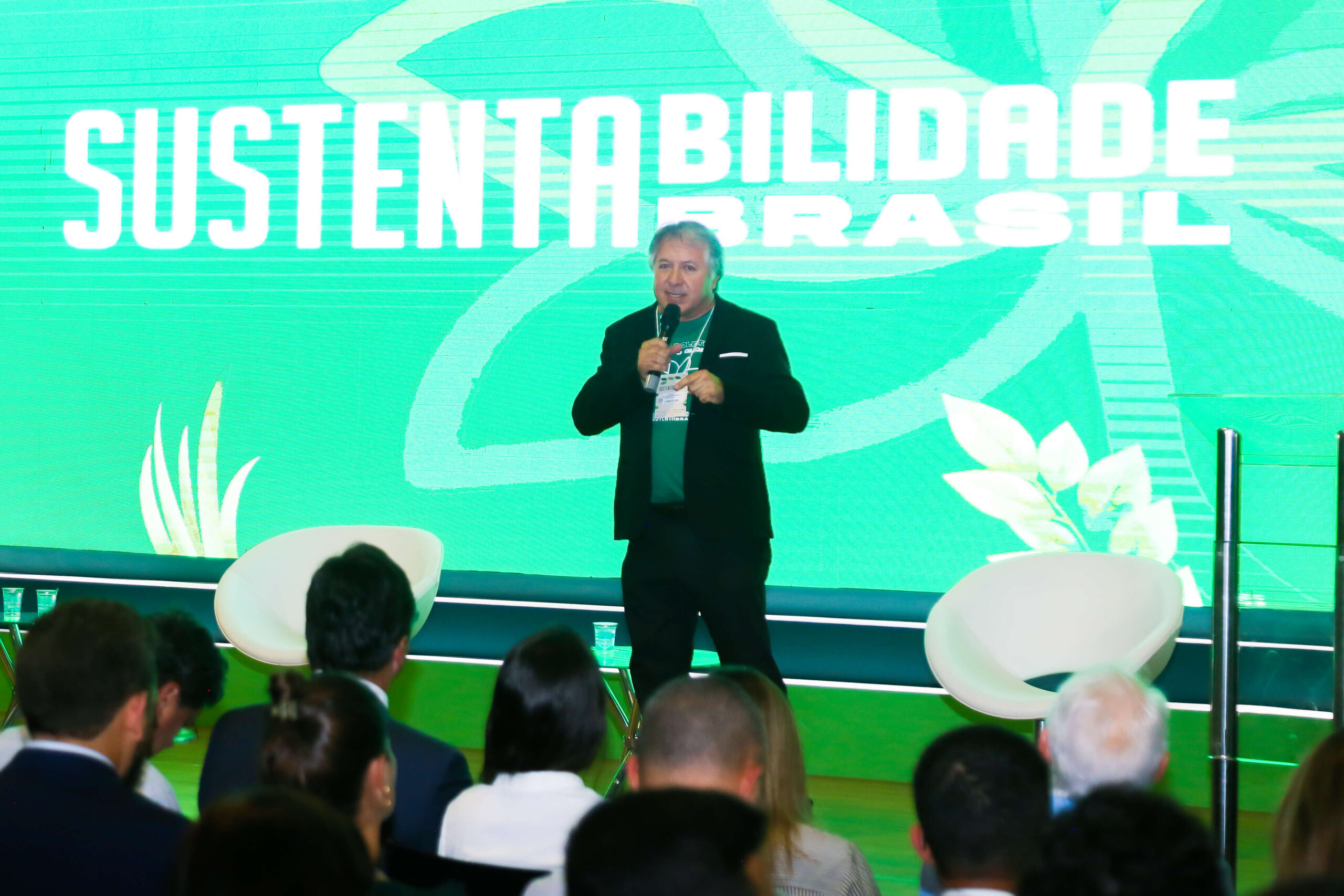 Elias Carvalho durante palestra na Conferência Sustentabilidade Brasil 2025, em Vitória, com painel verde ao fundo destacando o tema ambiental e público atento na plateia