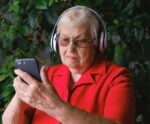 A foto mostra idoso ouvindo música