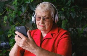 A foto mostra idoso ouvindo música