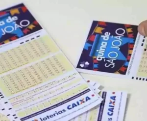 Resultado da Quina de São João: bolão do ES dividirá R$ 250 milhões Mão marcando números em um bilhete da Quina de São João 2025, com vários volantes das Loterias Caixa espalhados sobre a mesa.