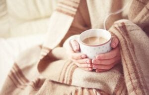 Pessoa com chocolate quente no alerta de frio