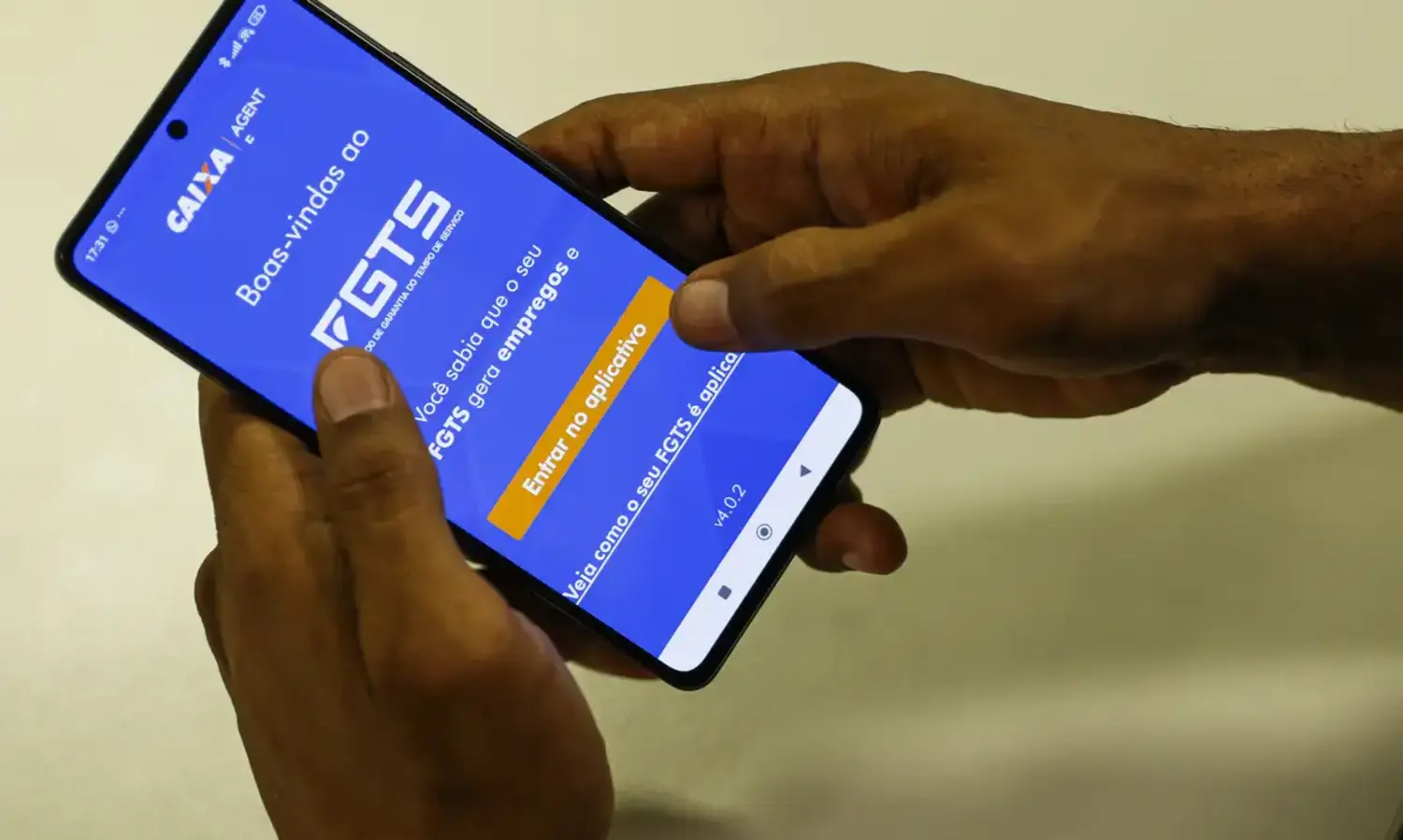 Pessoa acessando o aplicativo FGTS no celular para consultar saldo e verificar o depósito dos lucros do FGTS em 2024, conforme aprovação do Conselho Curador.