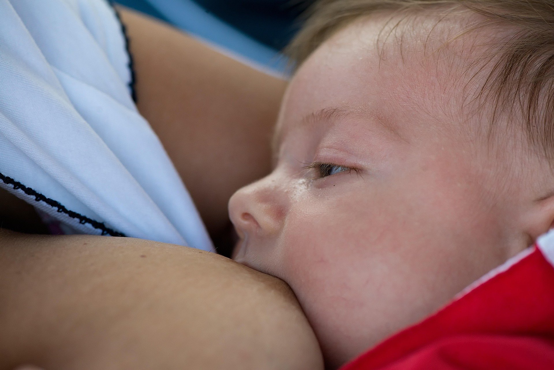 A foto mostra mãe amamentando filho em alusão ao Agosto Dourado