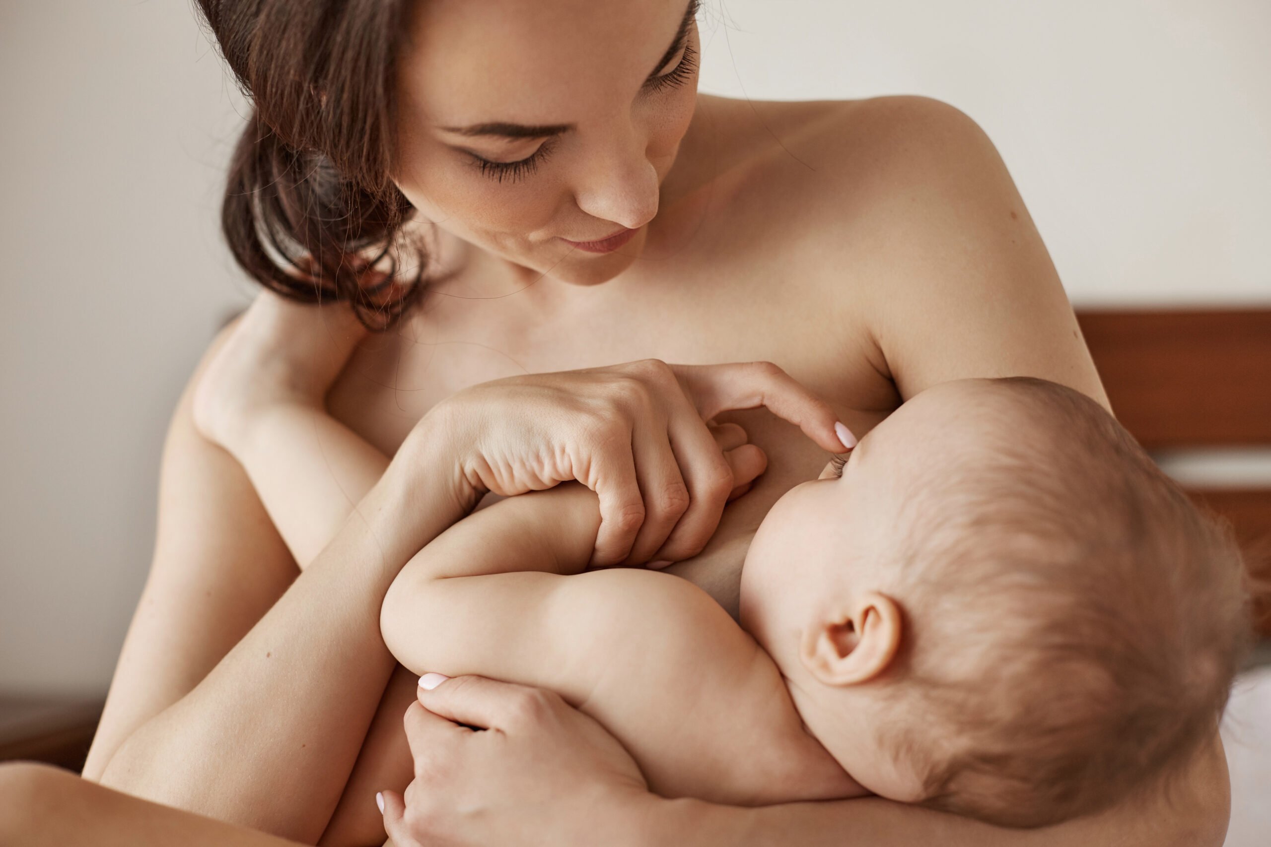 A foto mostra jovem mãe amamentando