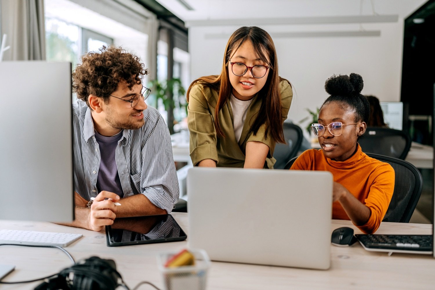 Three young colleagues discussing work at modern office