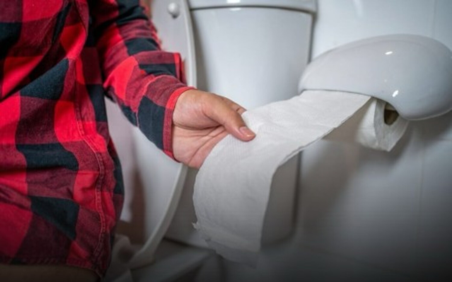 A foto mostra pessoa com celular no banheiro