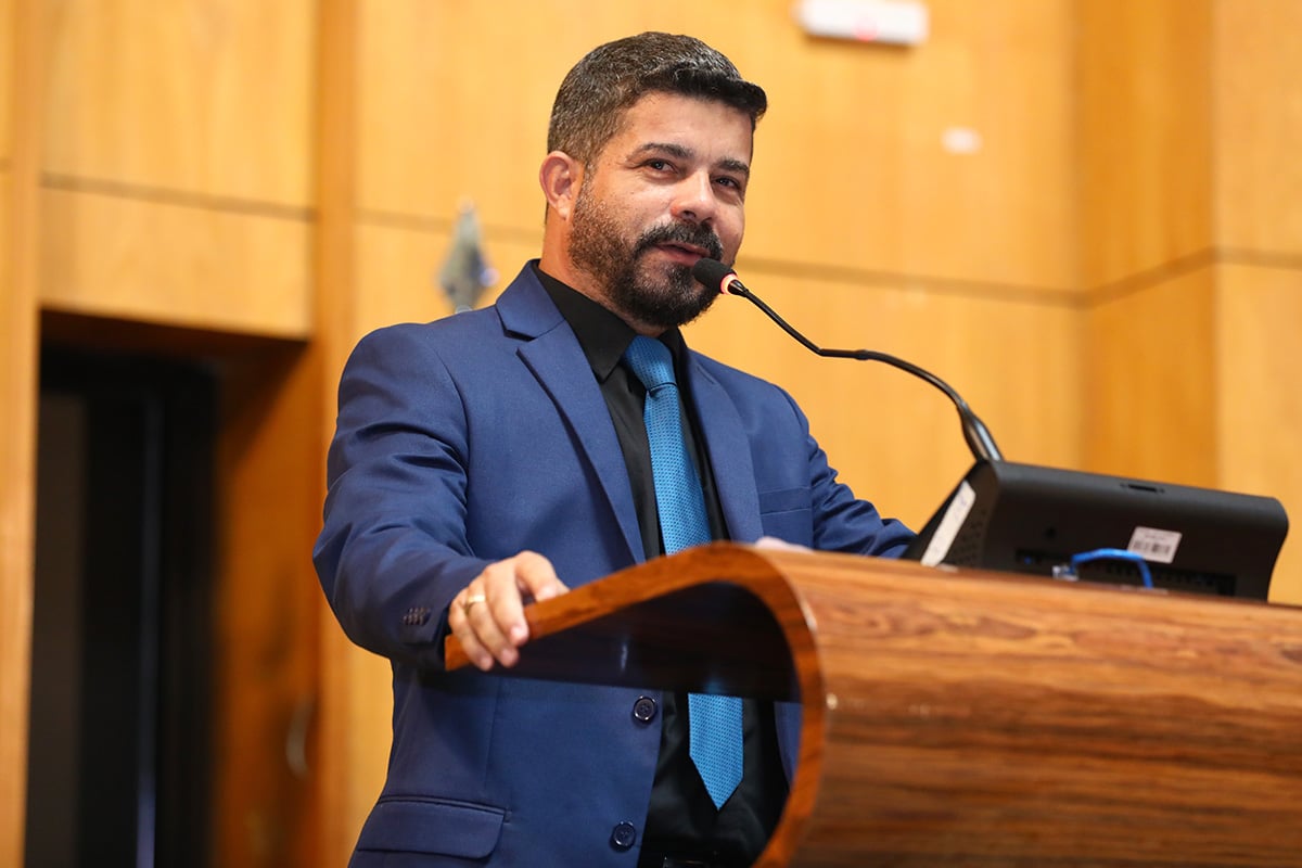 Foto mostra o deputado de frente com terno ciza e gravata azul falando sobre o cooperativismo no Espírito Santo