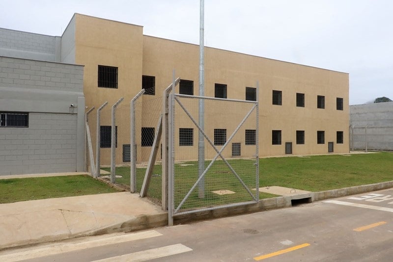 Fachada de um prédio do Complexo Penitenciário de Xuri, em Vila Velha, com paredes claras, janelas gradeadas e cercas de segurança ao redor da área externa.