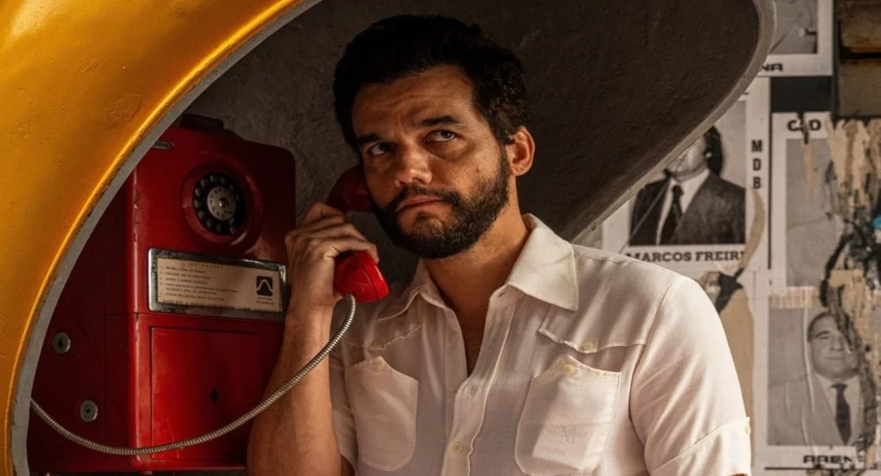 ator do filme o agente secreto falando em um telefone antigo