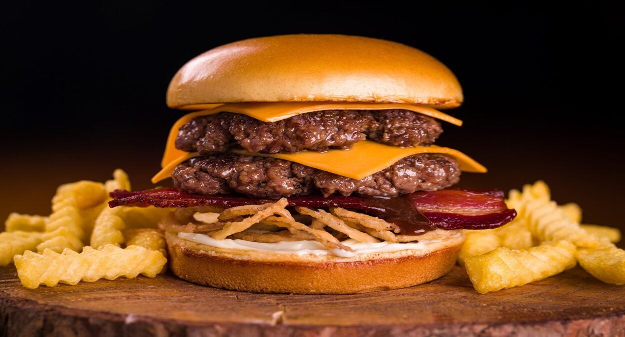 brutos burguer em itaoca - imagem de um hamburguer com batata em uma tábua de madeira