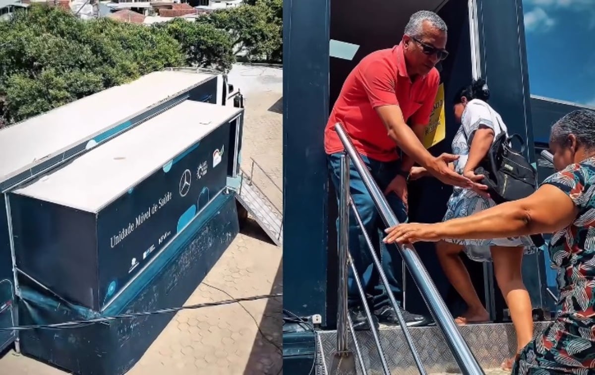 Carreta móvel de saúde estacionada em área urbana, com rampa de acesso lateral aberta. Ao lado, um homem de camisa vermelha auxilia moradores a subir a escada do veículo para atendimento, enquanto uma mulher segura no corrimão ao entrar na unidade.