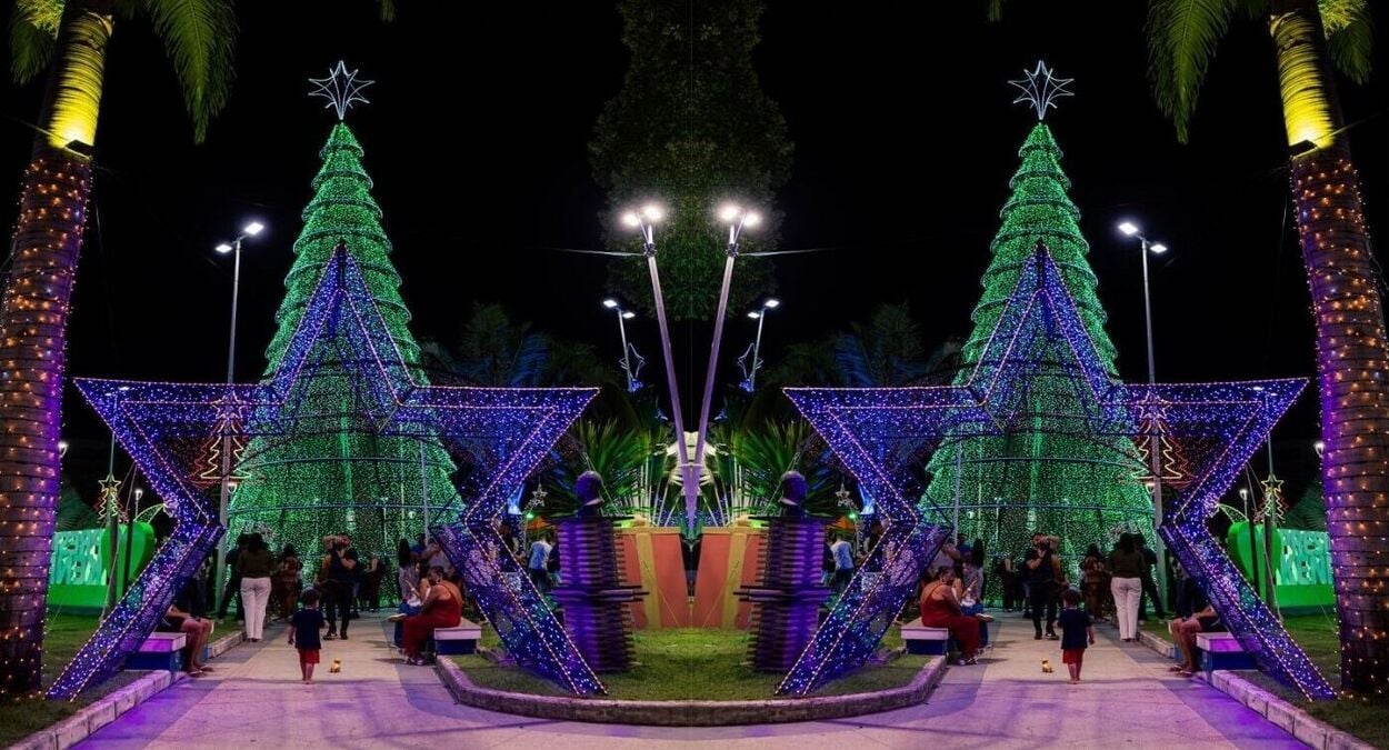 Decoração de Natal iluminada na Praça Manoel Fricks Jordão, em Presidente Kennedy, com árvores de Natal e estrelas coloridas. A imagem captura o brilho das luzes, refletindo o espírito festivo da cidade, marcando o início das celebrações natalinas. Frase-chave: acendimento das luzes em Presidente Kennedy.
