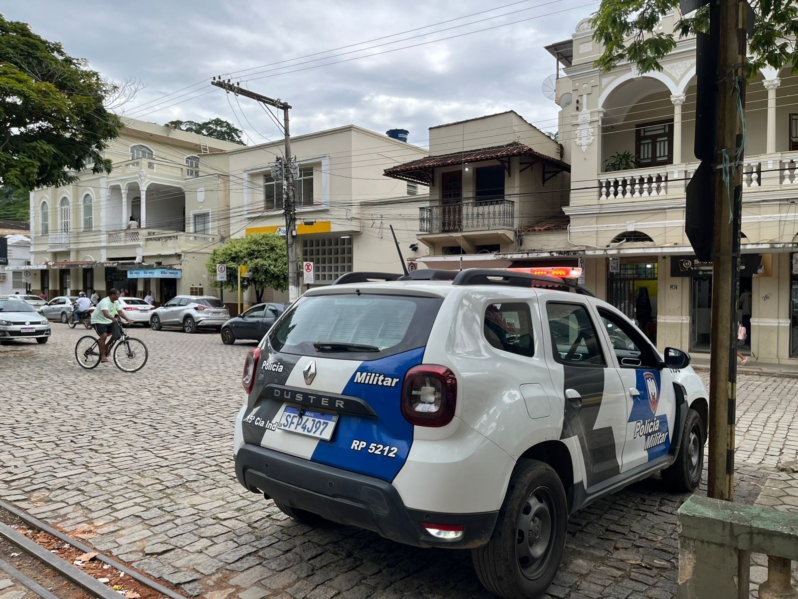 Imagem retrata rua com viatura estacionada.