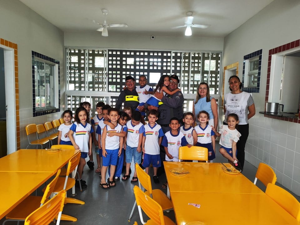 Imagem retrata crianças com policiais militares