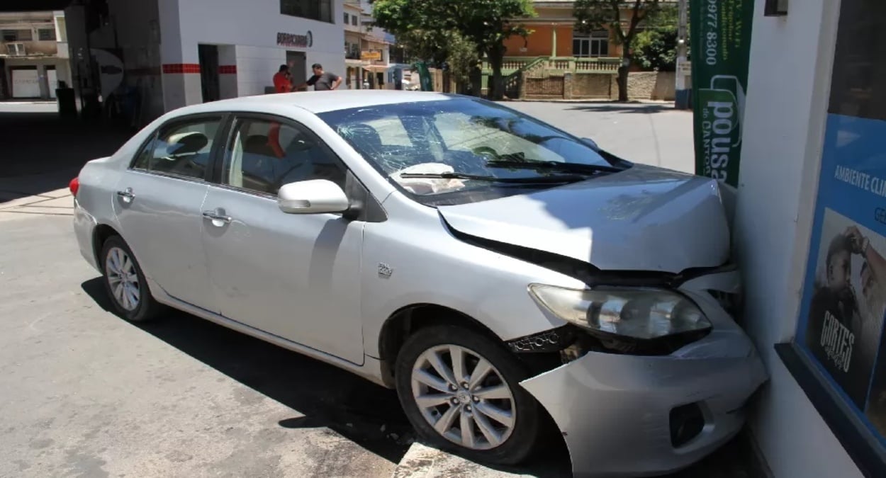 Carro prata com a frente destruída após colidir contra a parede de um estabelecimento no Centro de Mimoso do Sul.