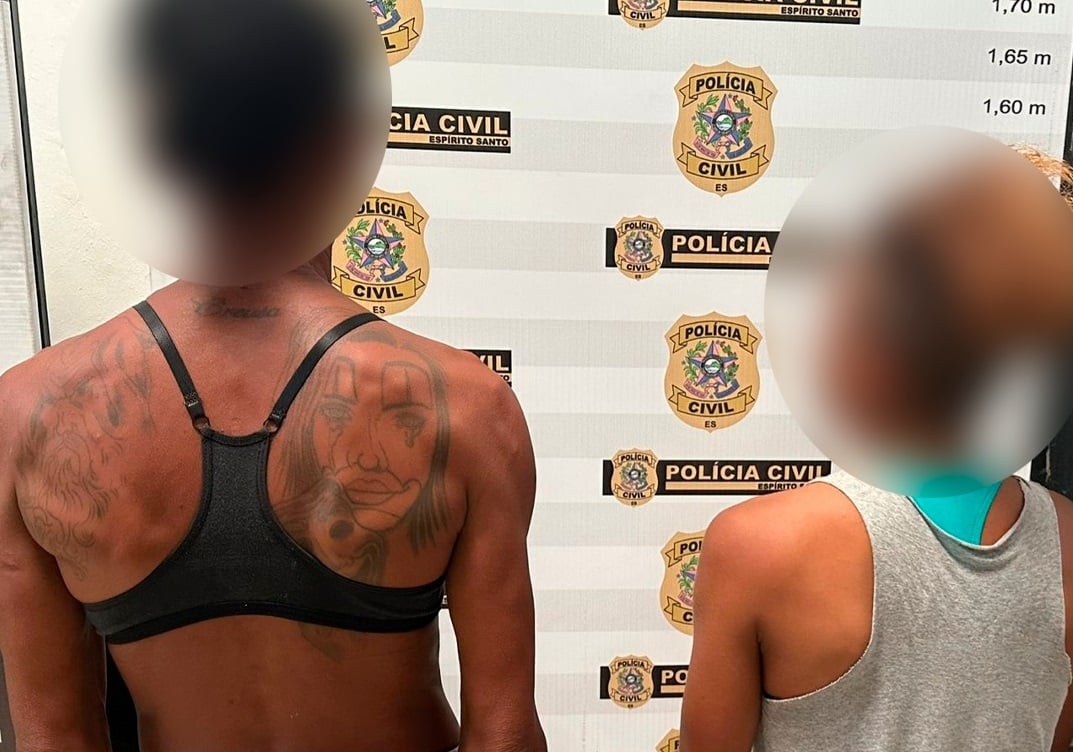 Duas mulheres com os rostos desfocados aparecem de costas diante do painel da Polícia Civil do Espírito Santo após serem detidas por ameaçar uma vítima com faca em Marataízes.