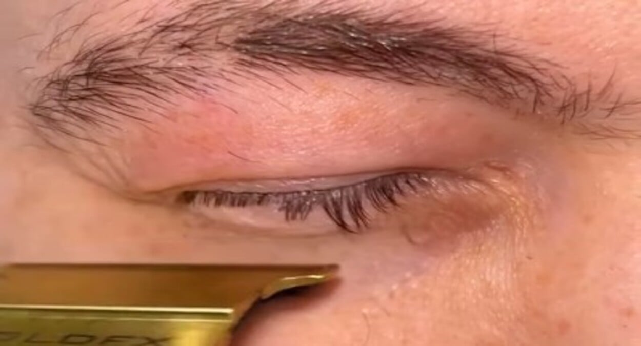 A foto mostra homem cortando cílios