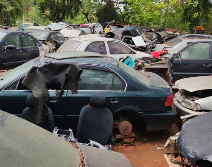 Imagem mostra carros em um pátio usado para desmanches de veículos.