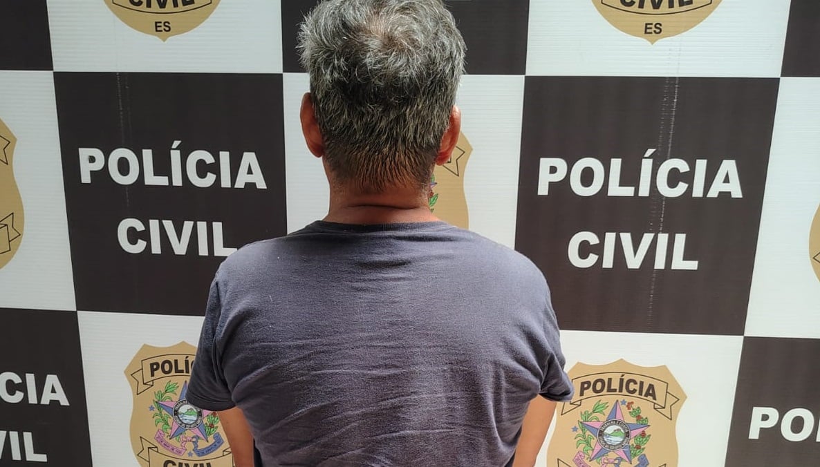 Imagem mostra home de costas na delegacia após ser preso por estupro.