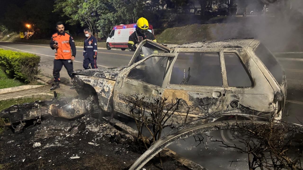Imagem mostra carro e moto incendiados após colisão.